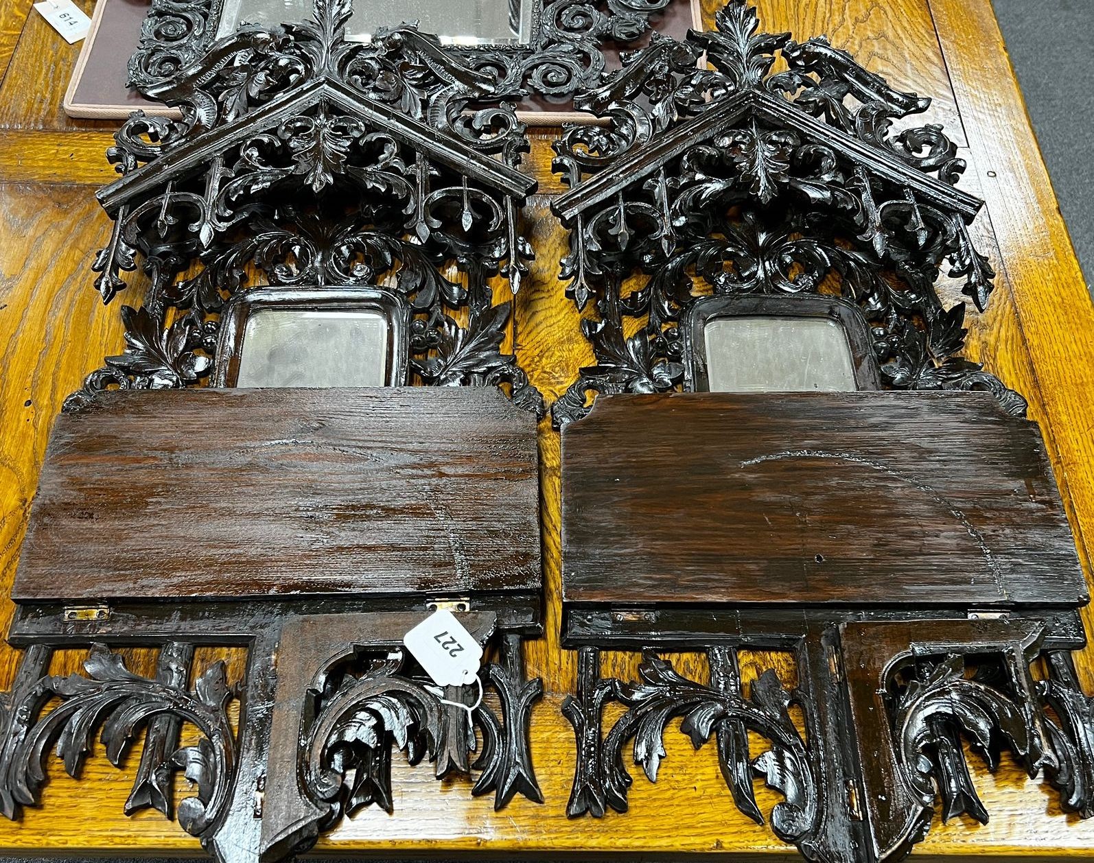 A pair of Black Forest carved folding mirrored wall brackets width 37cm height 81cm.